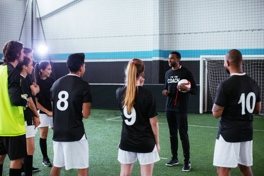 Soccer players training with a coach.