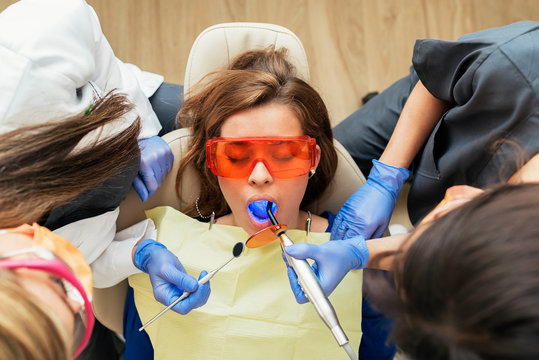 Dentist and assistant doctor during a dental intervention with a patient.