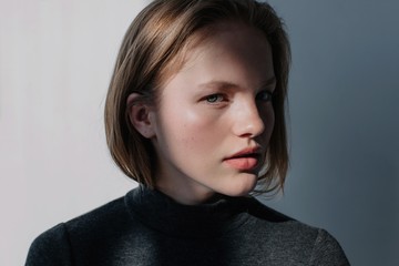 Portrait of pretty blond female posing in contrast daylight