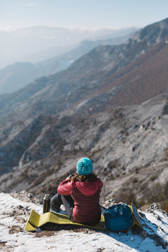 Hiker on a rocky outcrop enjoying a mountain view