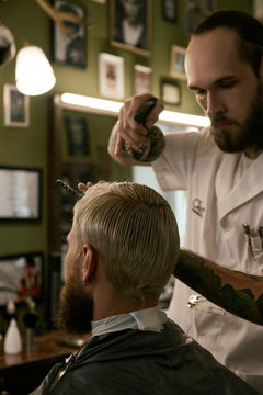Barber grooming client in chair