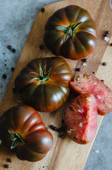 Obraz na płótnie Canvas Sweet Marmande tomato cut on wooden board. Top view.
