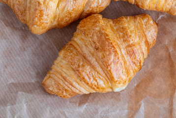 Aerial shot of butter croissants. On rustic paper background.