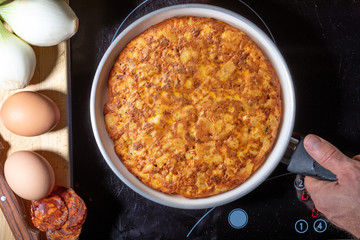 Close-up of homemade (Spanish) potato omelette with natural ingredients (fresh eggs, olive oil, potatoes, onion, chorizo)