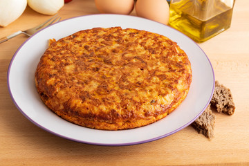 Close-up of homemade (Spanish) potato omelette with natural ingredients (fresh eggs, olive oil, potatoes, onion, chorizo)