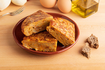 Close-up of portions of homemade (Spanish) potato omelette with natural ingredients (fresh eggs, olive oil, potatoes, onion, chorizo)