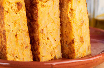 Close-up of portions of homemade (Spanish) potato omelette with natural ingredients (fresh eggs, olive oil, potatoes, onion, chorizo)