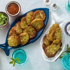 fish patties served on the table with red caviar, green onions and sour cream. fish homemade dish