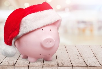 Piggy bank with Santa Claus hat on white background