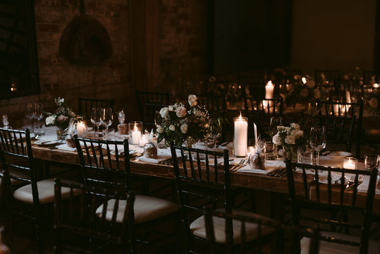 Wedding reception table decor on long wooden tables with pink flowers