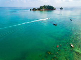Drone shot of green island in emerald waters in Kapas, Malaysia