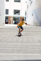 Front view of cheerful skater boy riding on the city in a sunny day