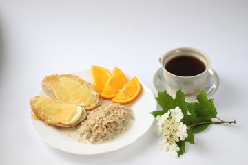breakfast consists of oatmeal cheese sandwiches and orange slices and a cup of coffee