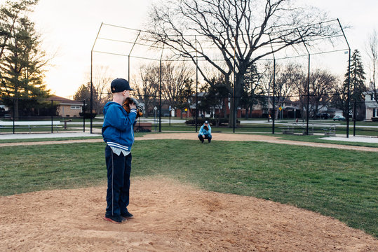 Young boy pitching a ball to his Dad as a catcher