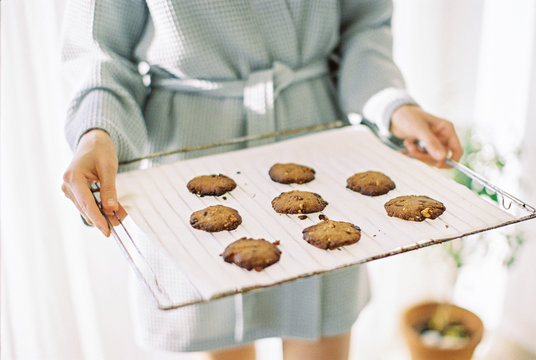 woman holding a baking pan with cookies - Powered by Adobe