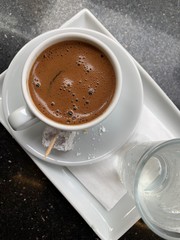 Turkish coffee with a glass of water and a few Turkish delight.