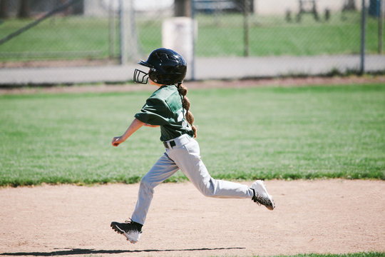 young girl running bases during baseball game