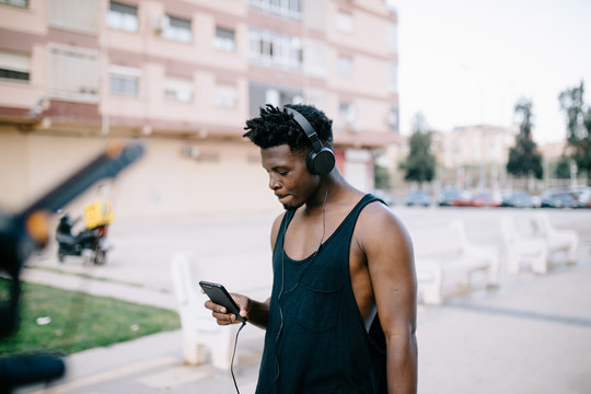 Casual black man with phone and headphones