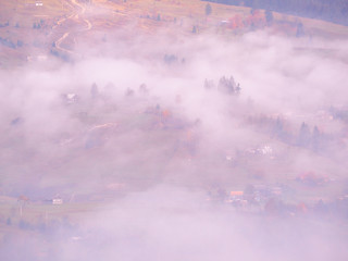 Carpatian village at mountains at the sunny foggy day