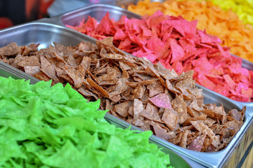 Multicolored vegetable chips on the market counter. Healthy snack