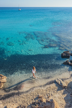Woman stepping into the water on exotic beach