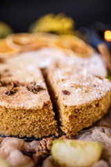 Biscuit apple pie with cinnamon, citron, oriental spices and sugar powder on dark background