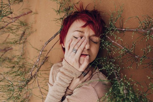 Redhead young woman daydreaming in desert