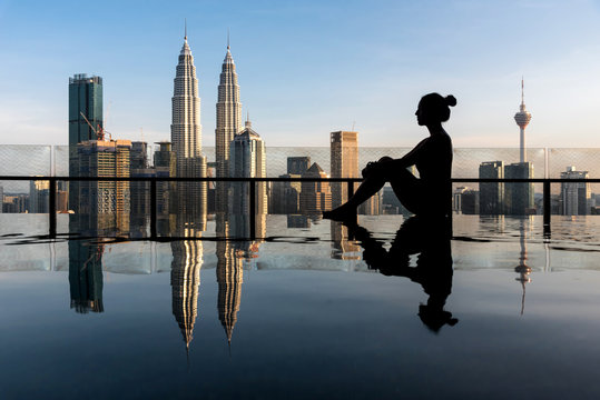 Womanin front of an urban infinity pool
