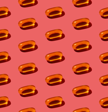 Fish oil capsules on dusty pink background