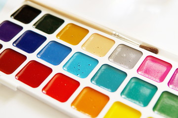 Tools of an watercolor artist-painter. White background, new beautiful paints and brashes. Close up.