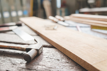 Equipment on wooden desk with man working in workshop background.