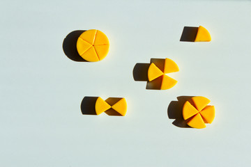 toy cheeses cut into pieces. concept of mathematical fractions and parts of one whole.