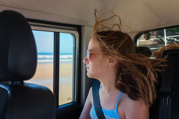 young teen in car at the beach