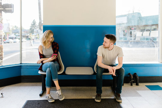 young couple sitting on a bench in store