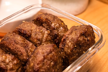 Grilled steaks in a glass plate on the kitchen table. Juicy cutlets close up