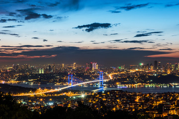 Naklejka premium Istanbul Bosphorus Bridge at sunset. 15th July Martyrs Bridge. Night view from Camlica Hill. Istanbul, Turkey.