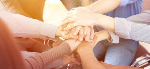 Group of people stacking hands together