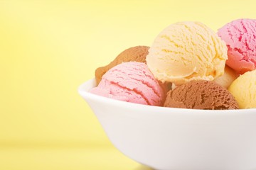 Ice cream scoops in bowl on white background
