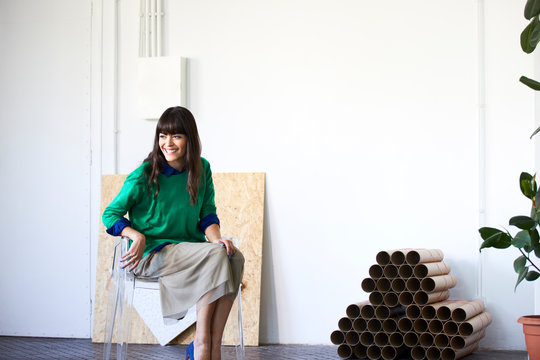 Smiling Creative Businesswoman Sitting On Chair