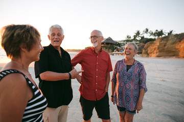 Four adult friends together on beach