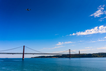 25 April Bridge over the Tagus river and airplane in the sky in Lisbon