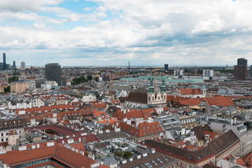 Fototapeta na wymiar Wien, Austria. May, 2019. Panorama of the city from the observation tower of St. Stephen’s Cathedral. Roofs of houses. In the distance, the Alpine Mountains. Sky view.