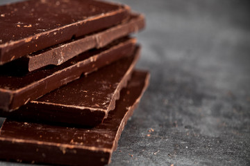 Dark chocolate bar pieces closeup. Sweet food photo concept.