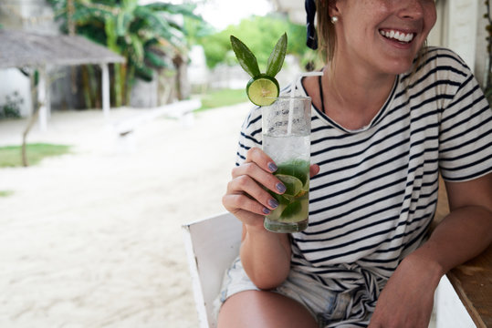 Latin girl smiling while drinking a healhty juice.