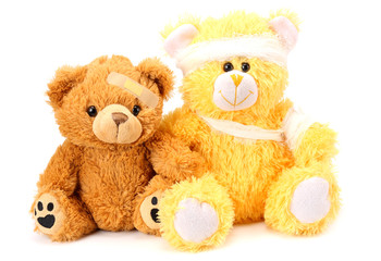 Two toy teddy bears with bandage isolated on white background