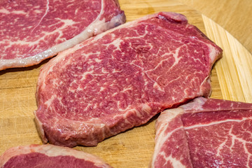 Raw Steaks on a cutting board on a wooden background. fresh meat