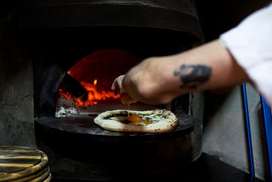 Crop man beating egg on flat bread