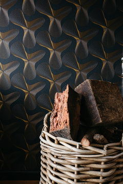 Basket of firewood against retro wallpaper