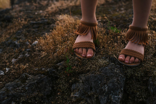 Girl's feet and sandals outside in nature