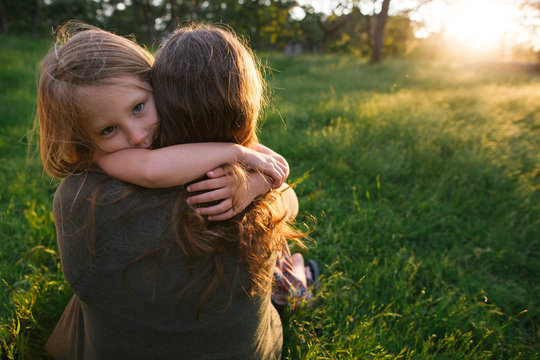 Girl hugging her mother outdoors